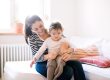 Adult caring for a young child in a warm home environment.
