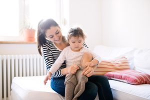 Adult caring for a young child in a warm home environment.